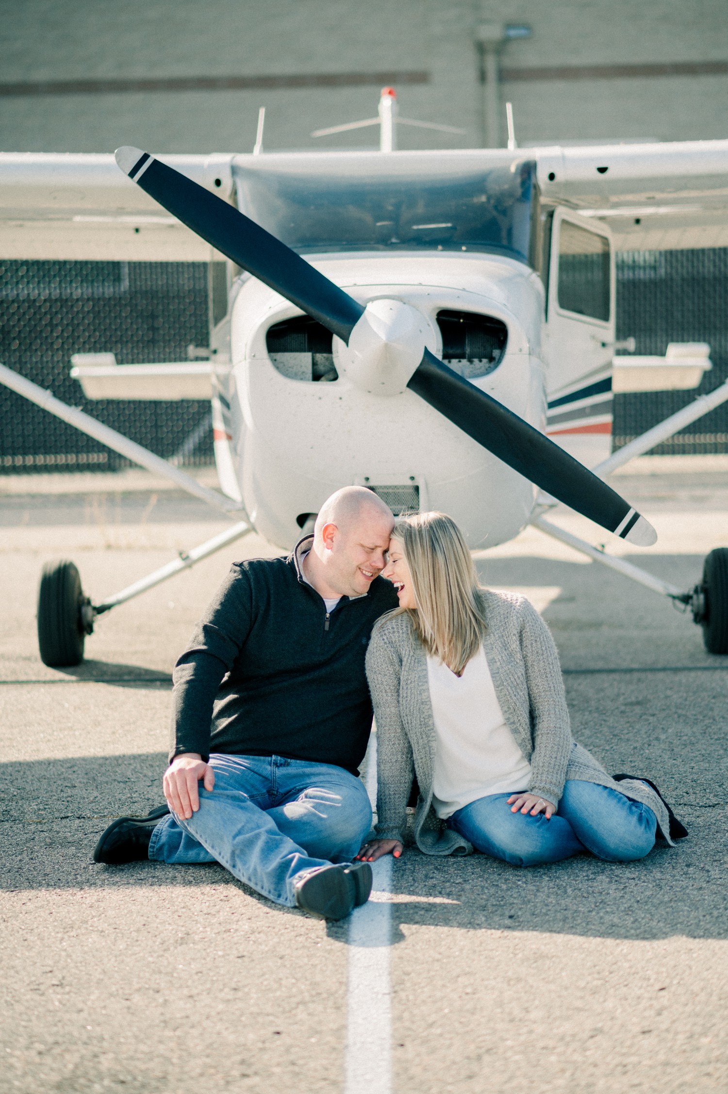 Engagement photos in front of airplane propeller.