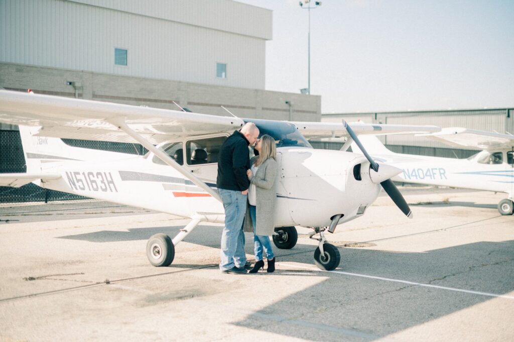 Engagement photos at Centennial airport in front of plane in Denver.