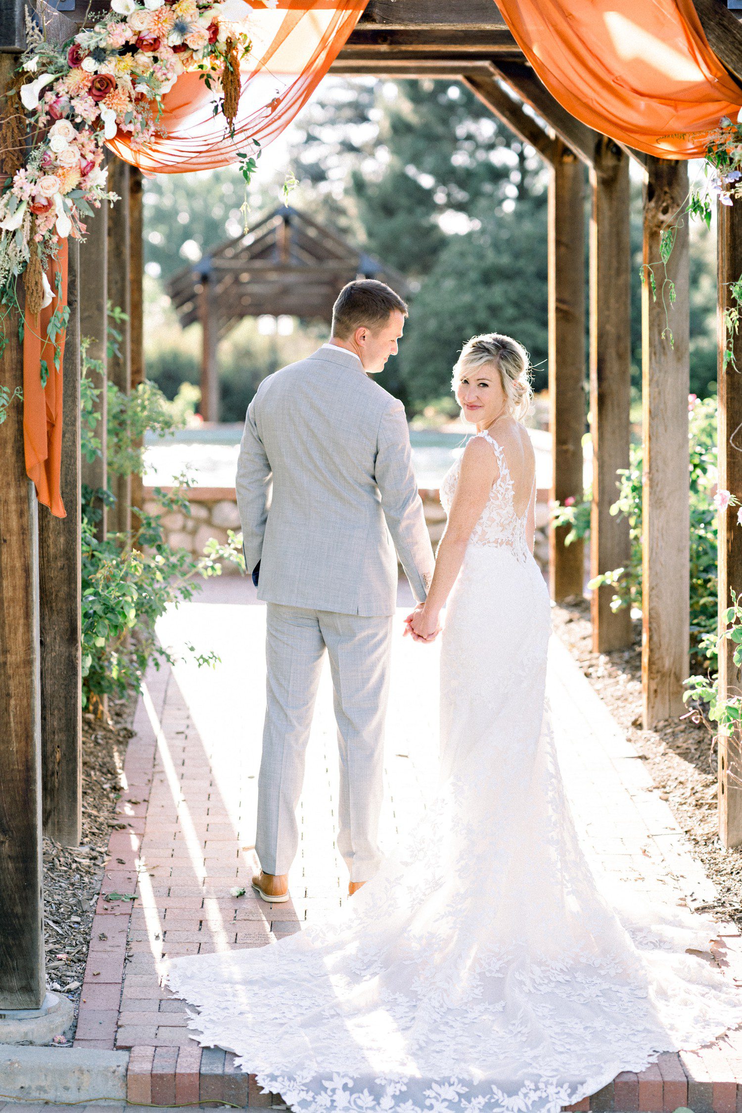 Wedding photos under pergola at Hudson Gardens in Denver.