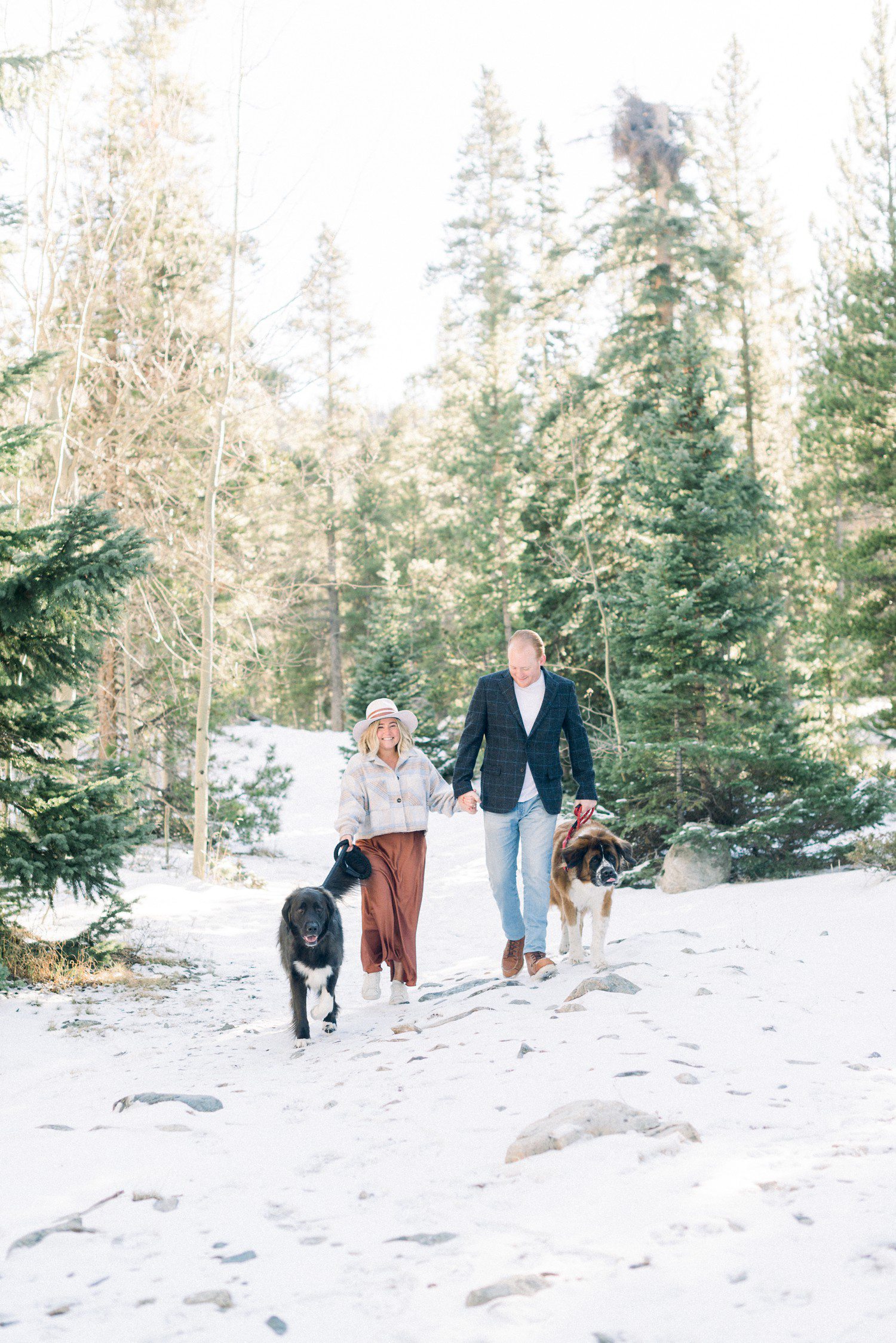Couple walking with dogs for engagement photos near Vail, CO.