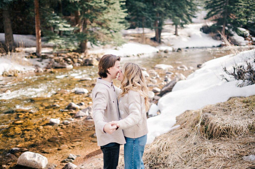 Snowy engagement photos in Vail Colorado by Gore Creek. 