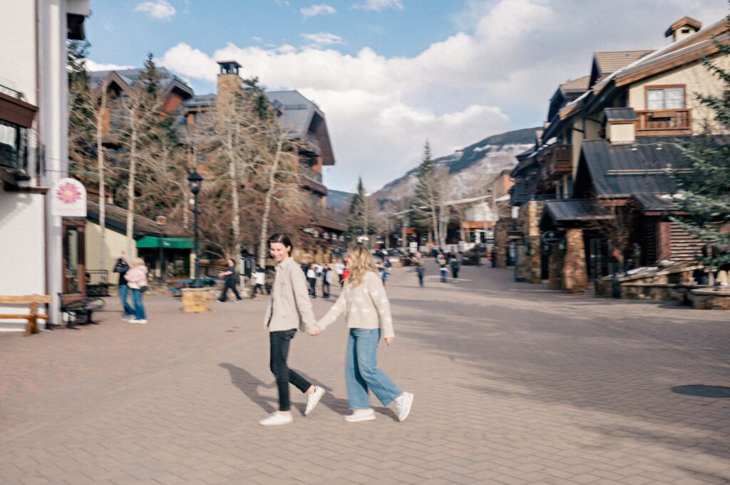 Couple walking through Vail Village for engagement photos. 